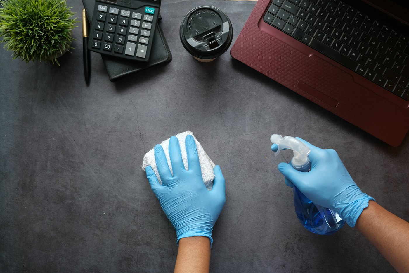 Désinfection d’un poste de travail avec gants et spray
